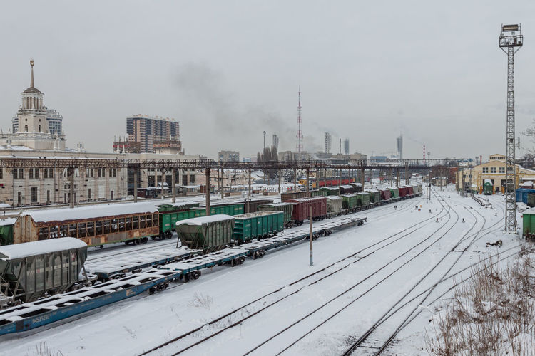 Train on snow covered railroad tracks against sky