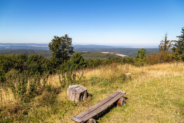 Scenic view on landscape from the mountain dolmar in thuringia with wooden bench in the foreground