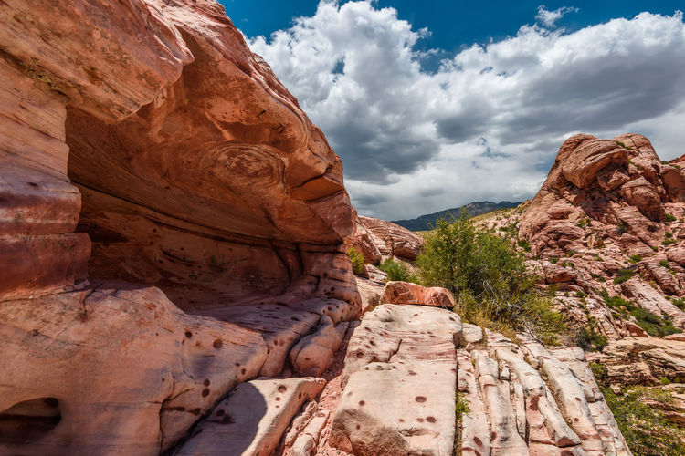 Low angle view of rock formations against cloudy sky