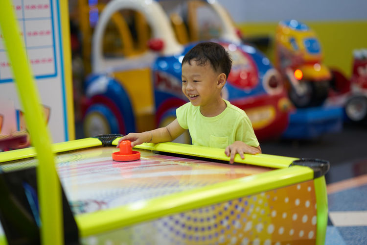Smiling boy playing air hockey