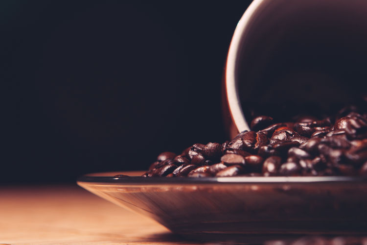 Close-up of coffee beans on table against black background