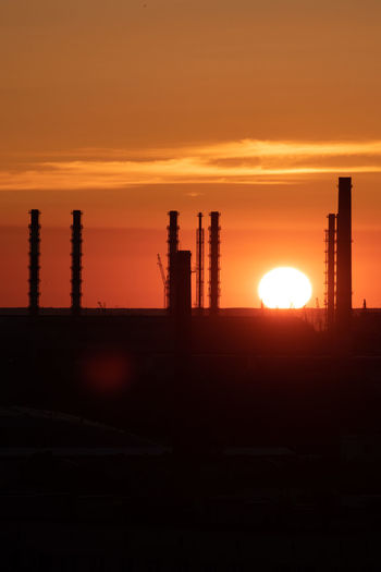 Silhouette of factory at sunset