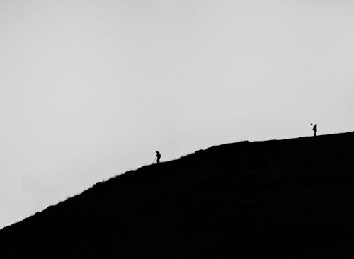 Silhouette person standing on mountain against clear sky
