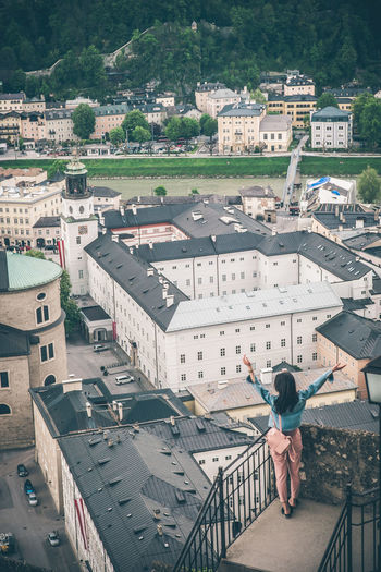 High angle view of woman standing by buildings in city