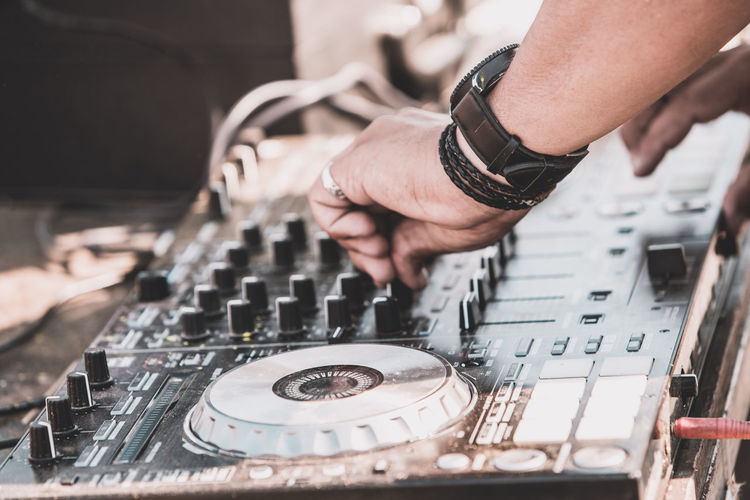 Cropped hands of musician adjusting sound mixer