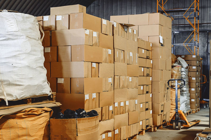 Cardboard boxes stacked in warehouse. boxes with goods prepared for shipment. loader