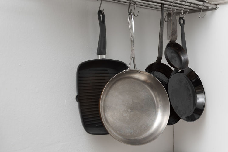 Close-up of utensils hanging against wall