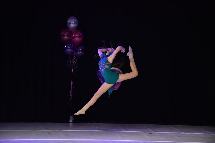 Full length of teenage girl dancing on stage