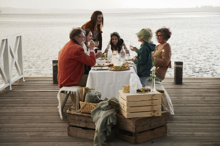 Family having midsummer dinner by lake
