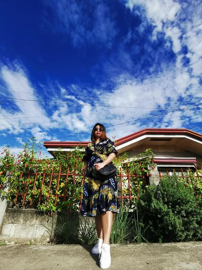 Woman standing against plants against sky