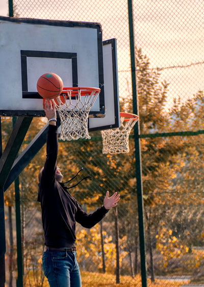 Man playing with basketball hoop