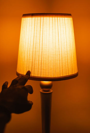 Close-up of electric lamp against wall at home