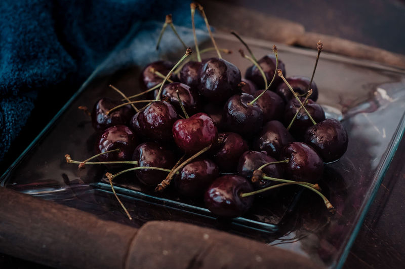 Fresh cherry on clear plate on wooden background. fresh ripe cherries. sweet cherries.