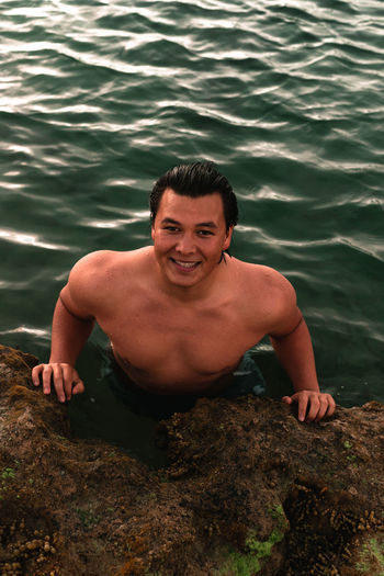 Portrait of young man smiling in sea