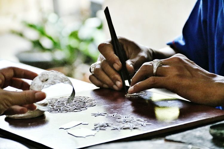Cropped image of man making jewelry at workshop
