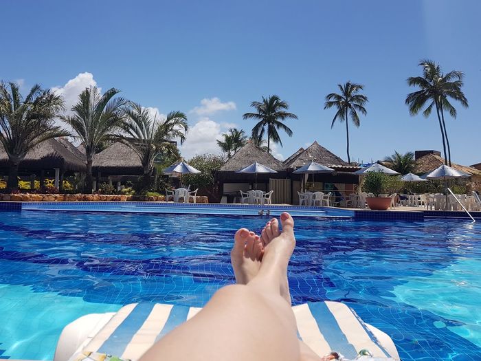 Low section of woman relaxing on swimming pool