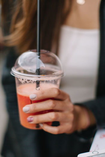 Close-up of woman holding drink in disposable cup