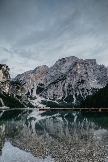 Scenic view of lake by snowcapped mountains against sky