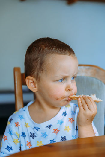 Close-up of boy eating food at home