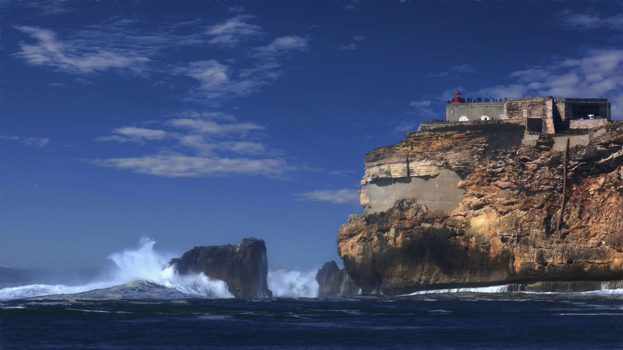 Painterly rendering of the rock and forte de são miguel arcanjo in nazare, potugal