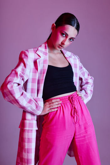 Young woman standing against gray background