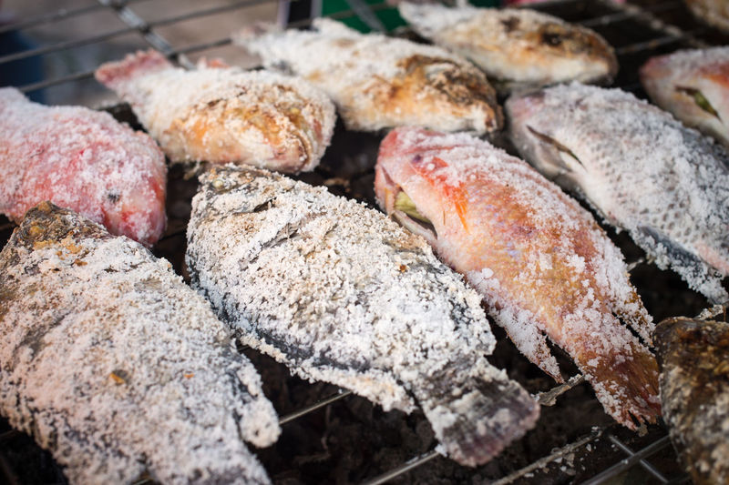 Close-up of salted fish cooking on barbecue