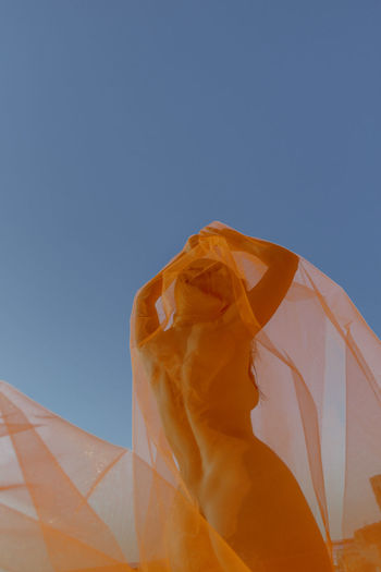 Low angle view of orange structure against blue sky