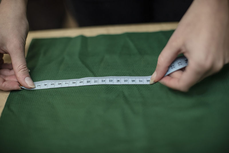Close-up of woman working with measuring tape in tailor shop