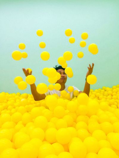 Man playing in ball pool against wall
