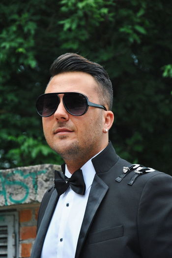 Portrait of young man wearing sunglasses while standing outdoors