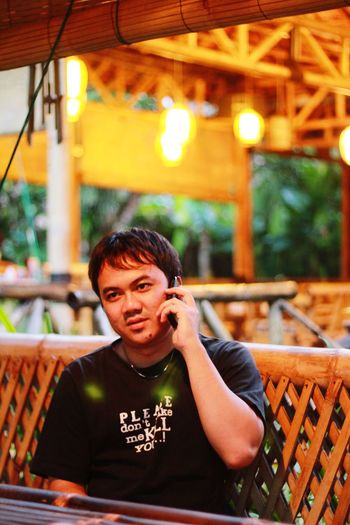 Portrait of young man using mobile phone at restaurant