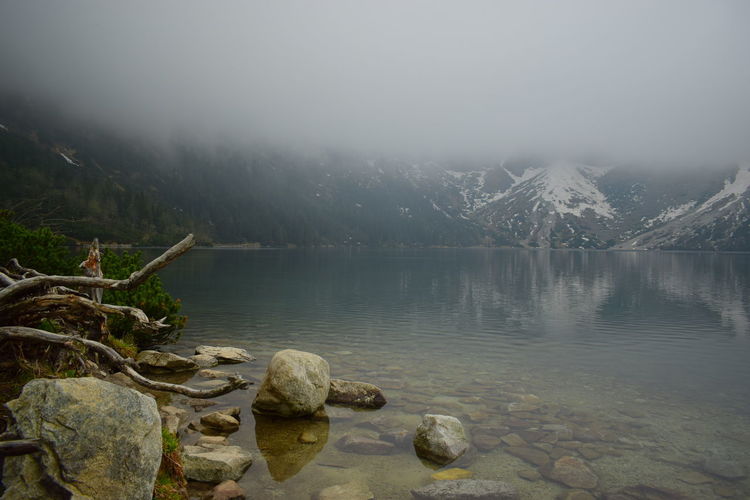 Scenic view of lake by mountains against sky