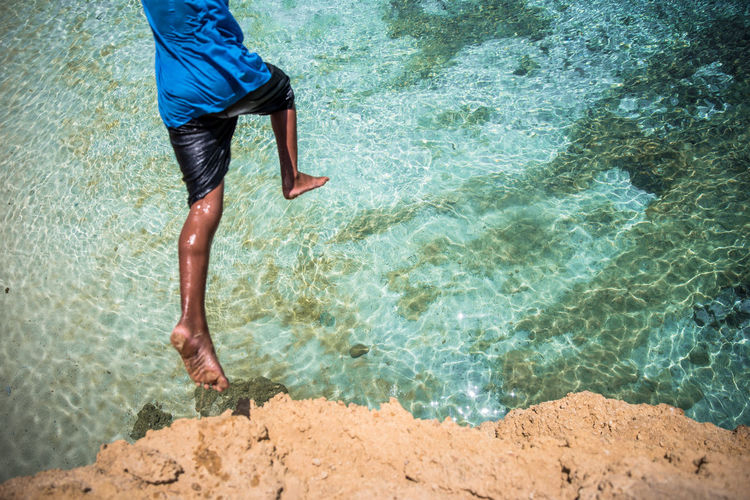 Low section of man standing on beach