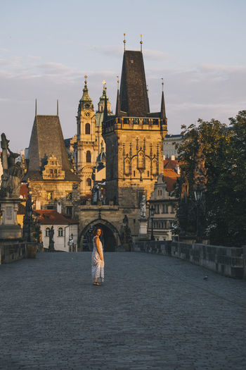 Woman walking through charles bridge, prague, czech republic