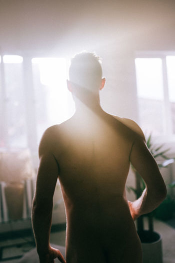 Rear view of shirtless man at home