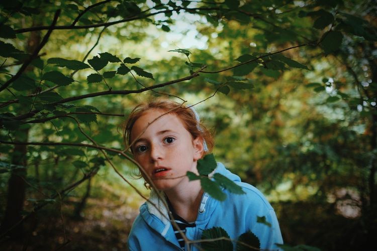 Portrait of girl with leaves in forest