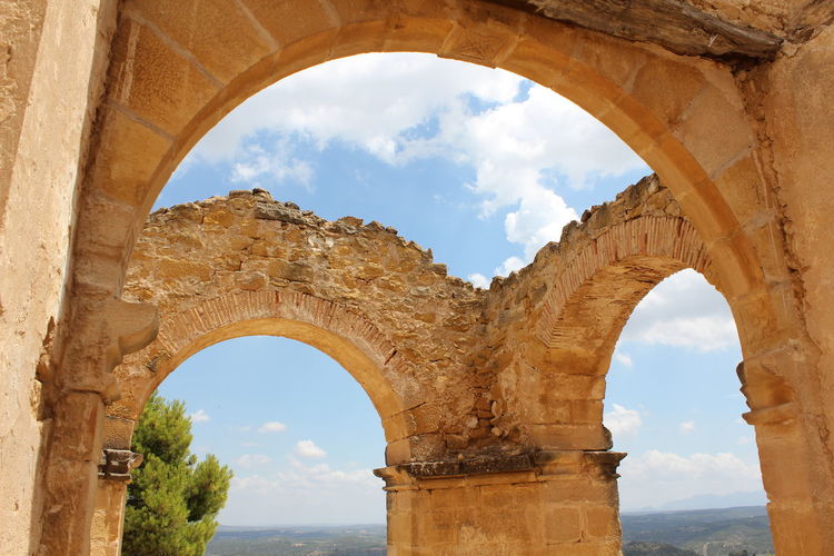 Low angle view of old ruins against cloudy sky