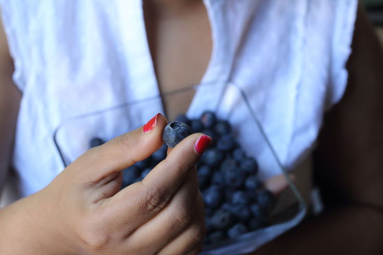 Close-up of woman eating berry fruit