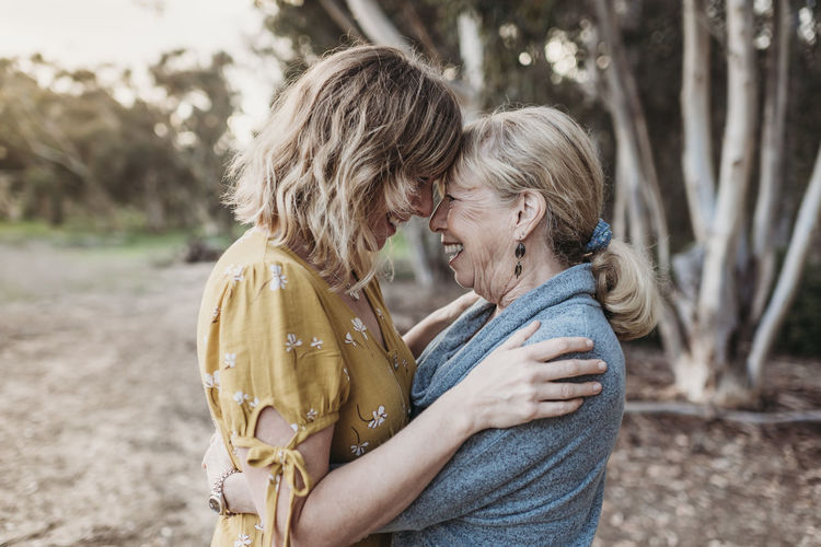 Lifestyle portrait of adult mother and senior mother smiling