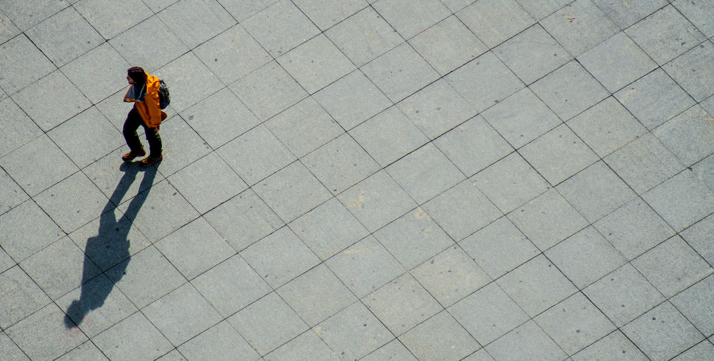 High angle view of man walking on pedestrian zone