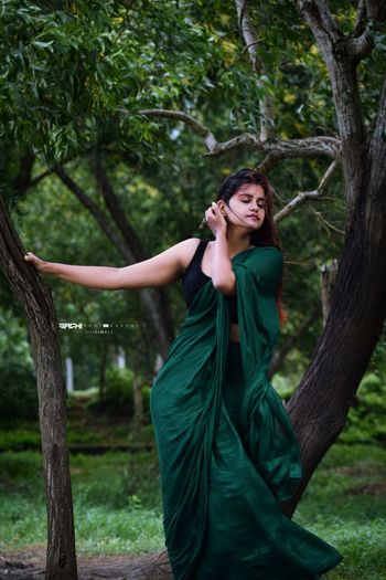 Portrait of young woman standing against trees