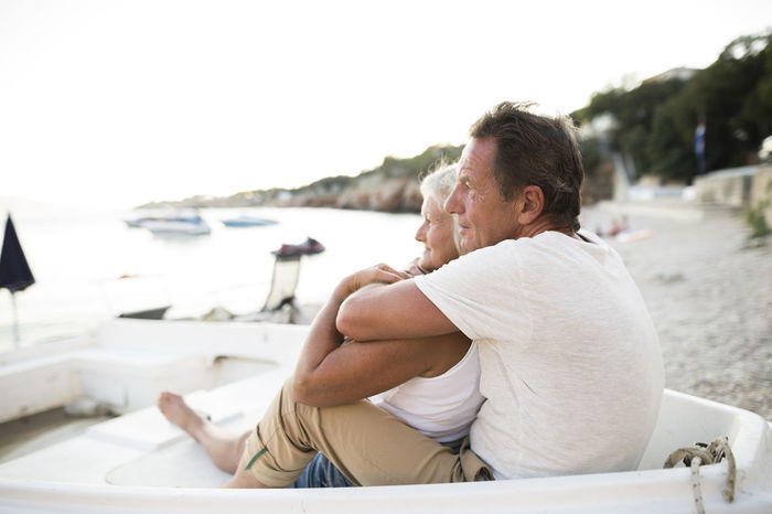 Senior couple relaxing in a boat on the beach in the evening
