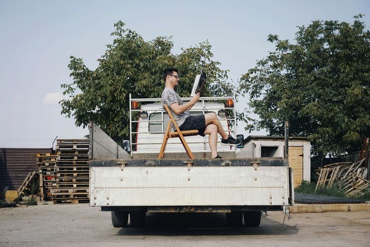 Side view of man sitting on chair in semi-truck