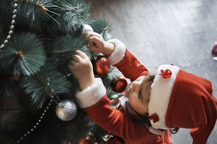 High angle view of baby girl in christmas tree