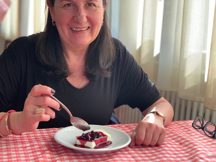 Portrait of smiling woman having dessert in restaurant