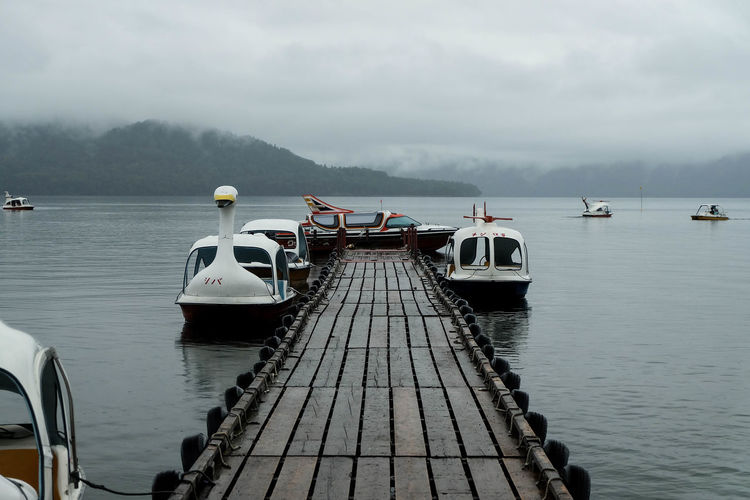 Motorboats moored at pier on caldera lake at akan national park