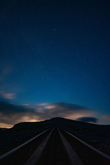 View of railroad track against sky at night