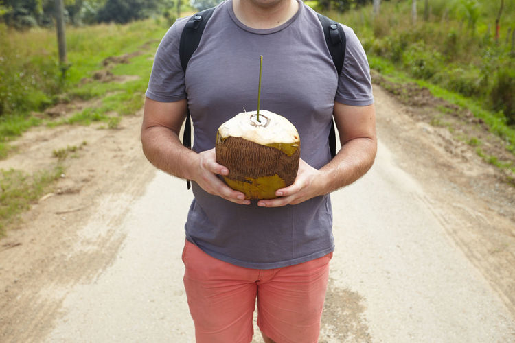 Full length of a man holding coconut