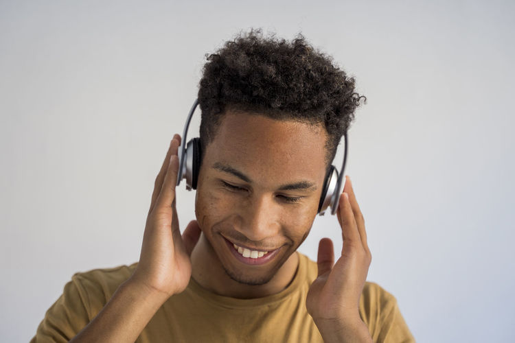 Close-up of man with headphone against white background