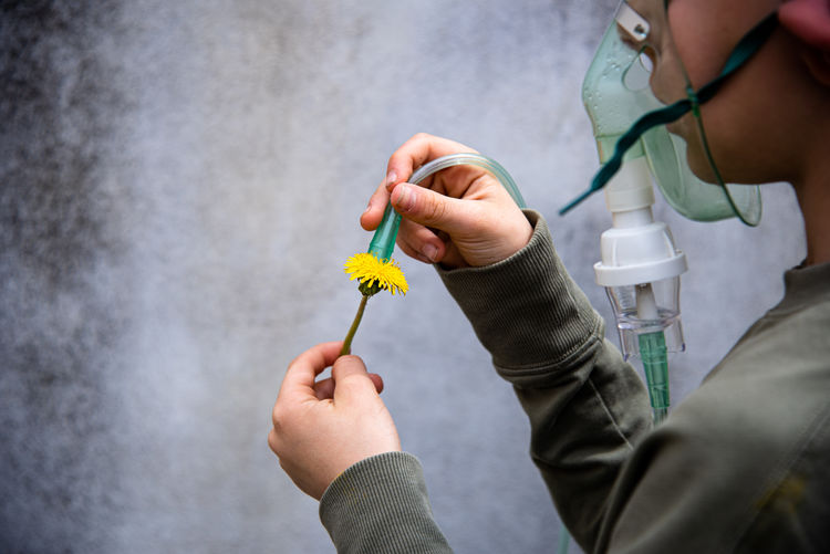 Closeup view of a boy holding yellow flower